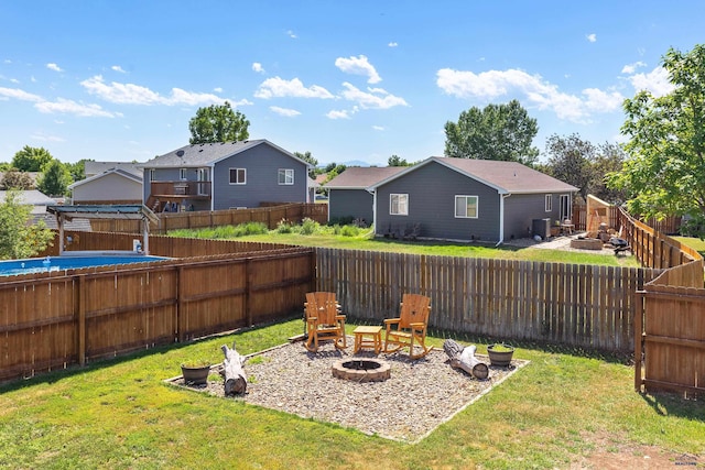 view of yard featuring a residential view, a fenced backyard, and a fire pit