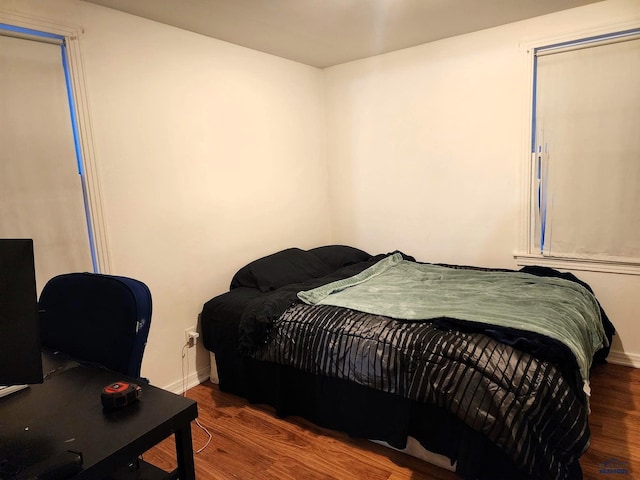 bedroom featuring wood finished floors and baseboards