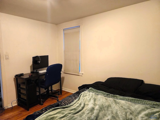 bedroom with baseboards and wood finished floors