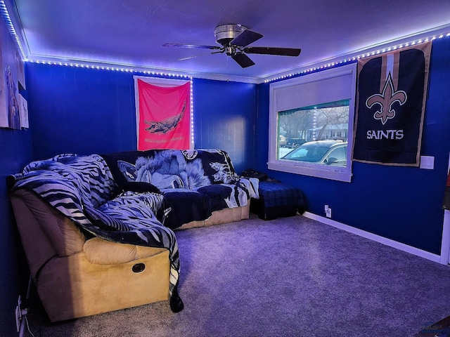 cinema with baseboards, carpet, a ceiling fan, and crown molding