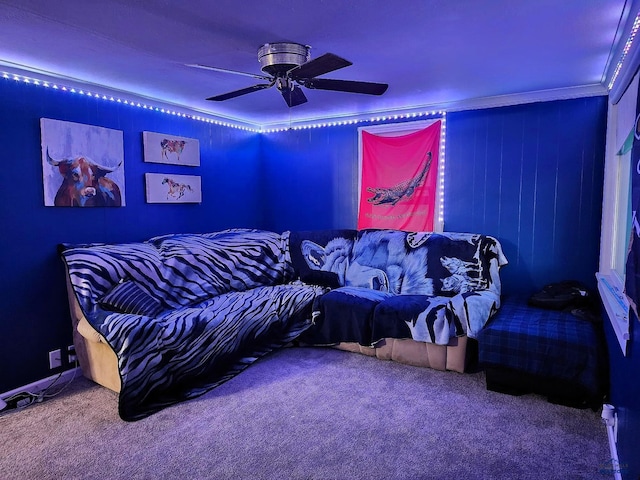 cinema room with crown molding, a ceiling fan, and carpet flooring