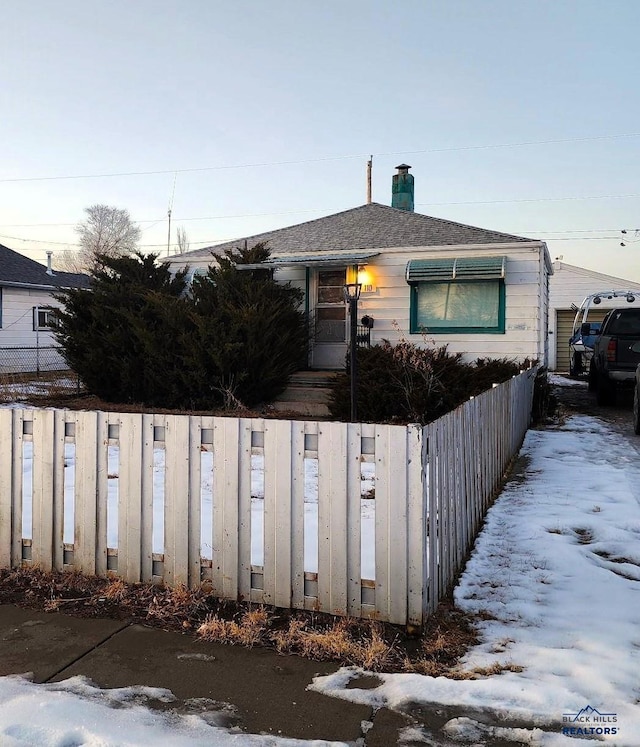 view of front of property with a fenced front yard and a chimney