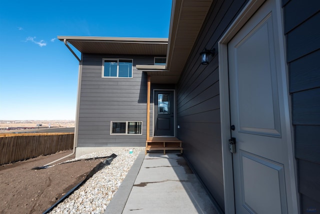 view of exterior entry featuring fence