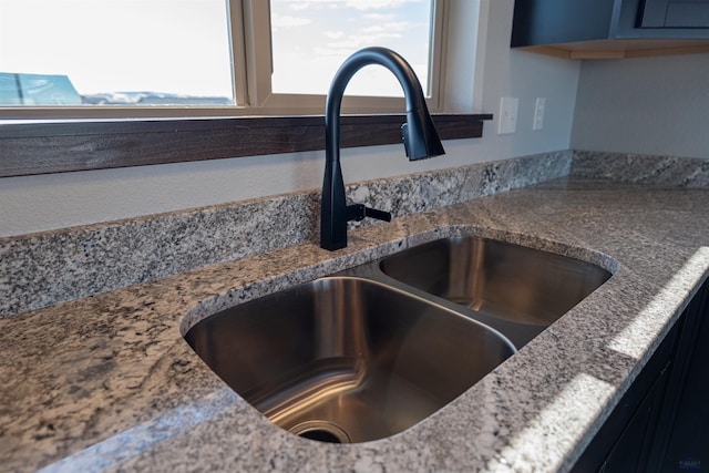 details featuring stone countertops and a sink