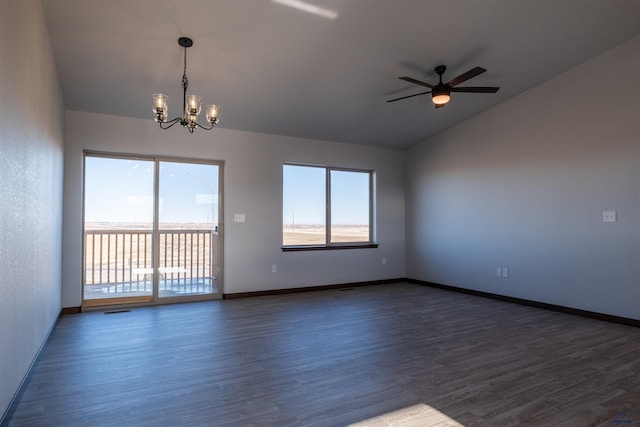 empty room with lofted ceiling, ceiling fan with notable chandelier, dark wood finished floors, and baseboards