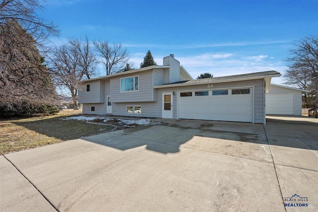 view of front of house featuring concrete driveway, a chimney, and an attached garage