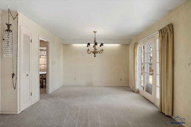 carpeted spare room with a notable chandelier