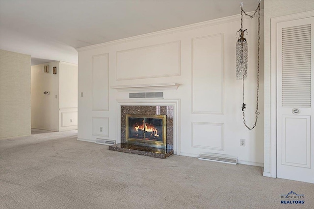 unfurnished living room with carpet, visible vents, a decorative wall, and a high end fireplace