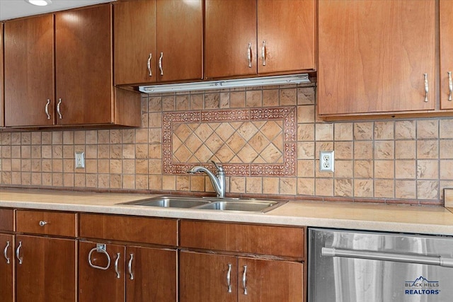 kitchen with light countertops, a sink, backsplash, and dishwasher