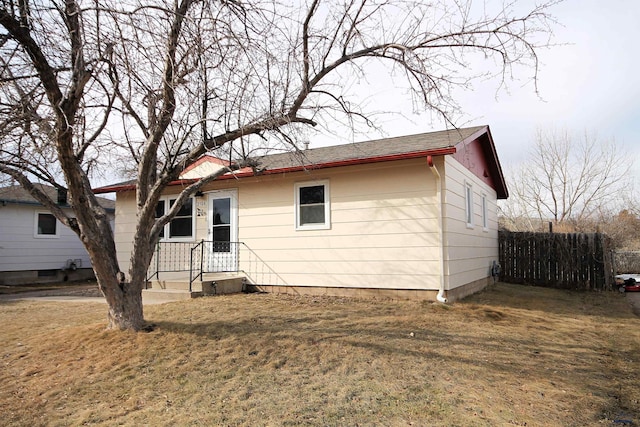 single story home with a front lawn and fence