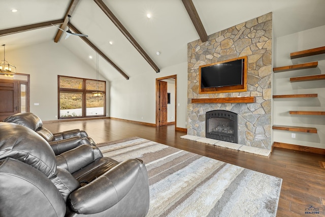 living area featuring baseboards, hardwood / wood-style floors, a stone fireplace, high vaulted ceiling, and beam ceiling