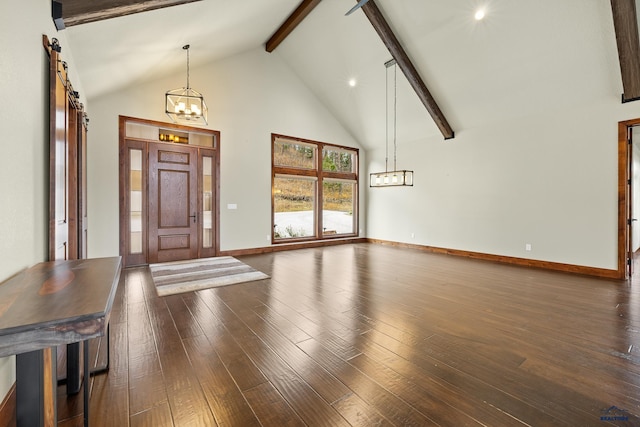 foyer with a barn door, dark wood-type flooring, beam ceiling, high vaulted ceiling, and a notable chandelier