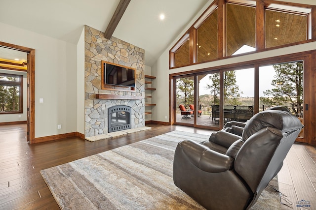 living area featuring a fireplace, high vaulted ceiling, beamed ceiling, baseboards, and hardwood / wood-style flooring