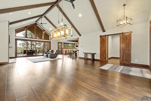 living room with a barn door, beamed ceiling, wood finished floors, high vaulted ceiling, and ceiling fan with notable chandelier