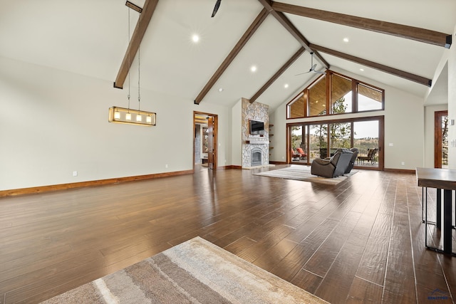 unfurnished living room with high vaulted ceiling, beam ceiling, a fireplace, and wood finished floors