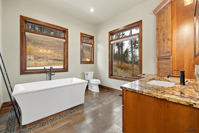 full bath featuring recessed lighting, a soaking tub, toilet, vanity, and baseboards