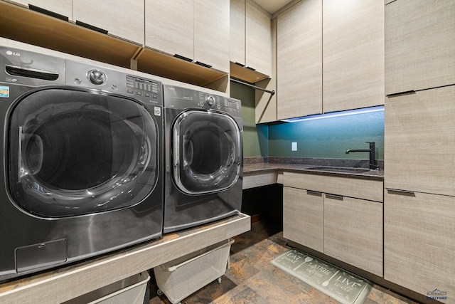 washroom with stone finish flooring, separate washer and dryer, a sink, and cabinet space