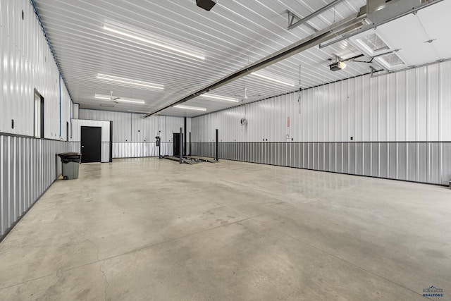 garage with a garage door opener and metal wall