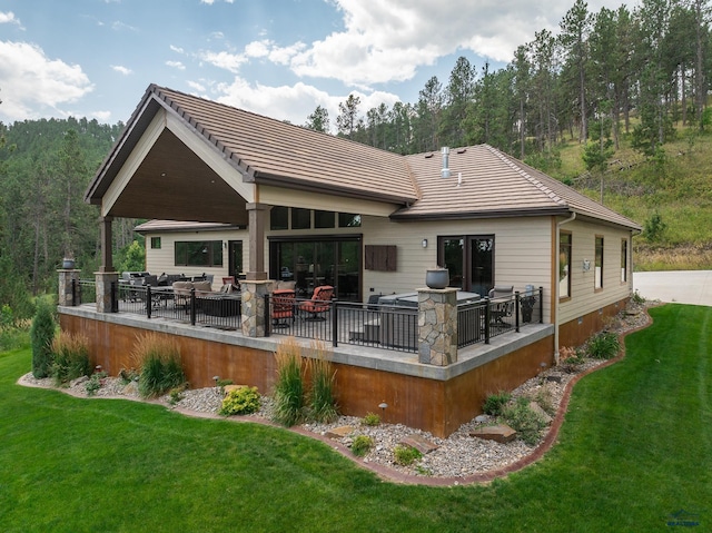 back of property with a patio area, a tile roof, and a lawn