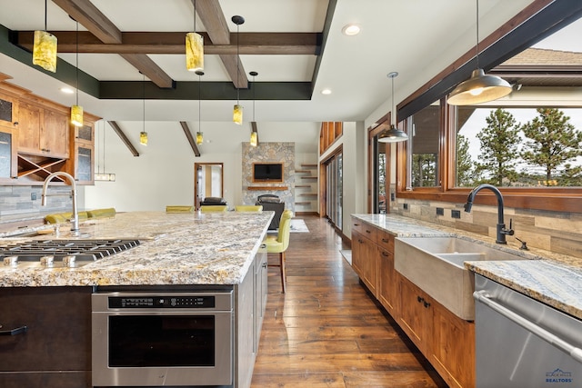 kitchen featuring dark wood-style floors, stainless steel appliances, coffered ceiling, and a sink