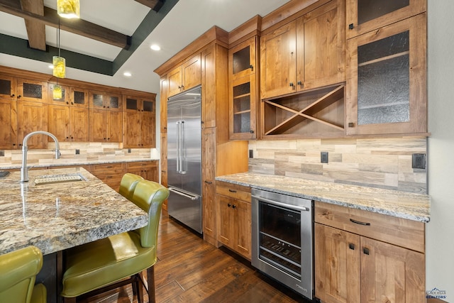 kitchen with built in fridge, beverage cooler, brown cabinets, and dark wood-style flooring