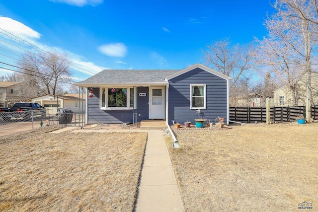 bungalow-style home featuring fence and roof with shingles