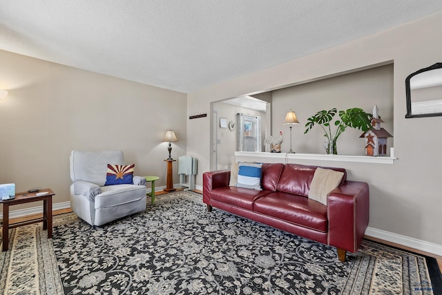 living room featuring a textured ceiling and baseboards