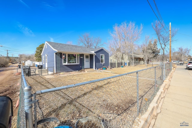 view of front of property featuring a fenced front yard and a shingled roof