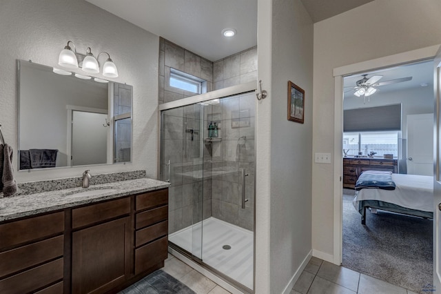 full bath with a textured wall, tile patterned flooring, baseboards, a stall shower, and ensuite bath