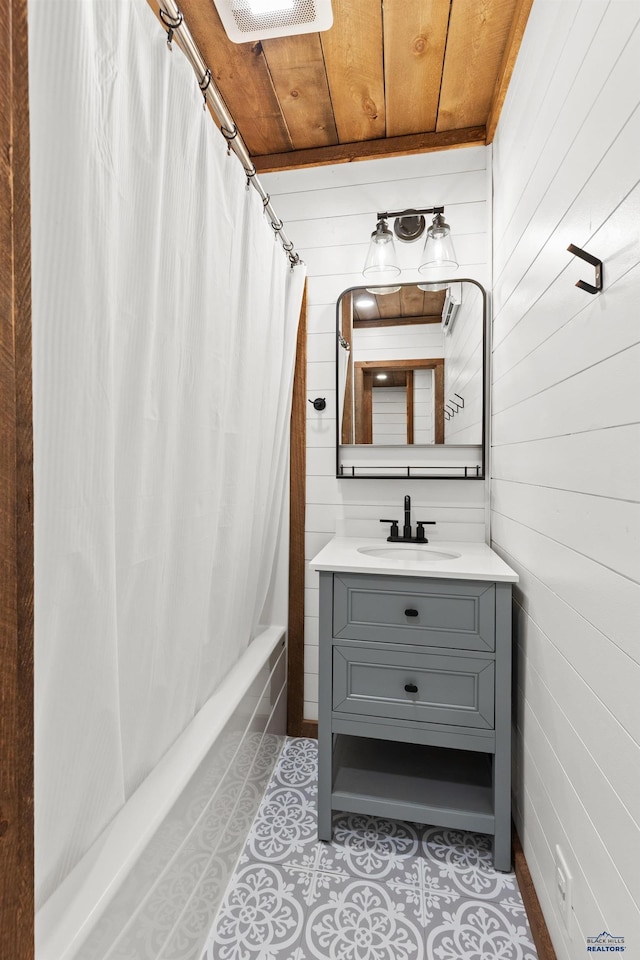 full bath with shower / tub combo, wood ceiling, wooden walls, vanity, and tile patterned flooring