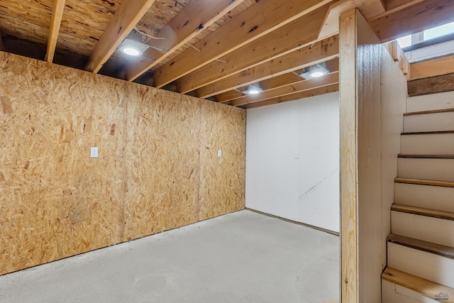 unfinished basement featuring stairs