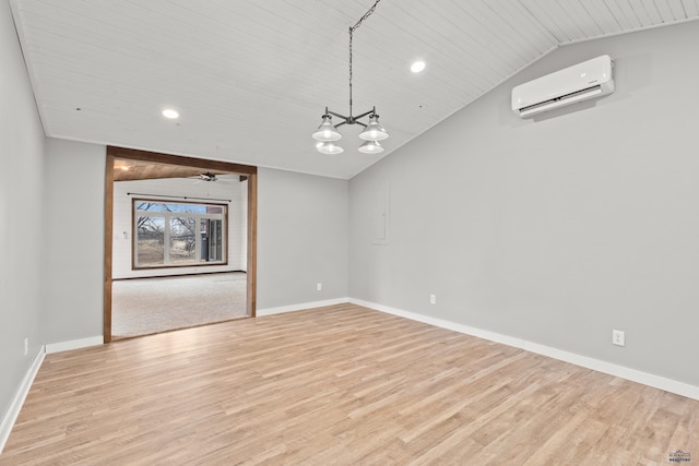 unfurnished room featuring light wood-type flooring, lofted ceiling, baseboards, and a wall mounted AC