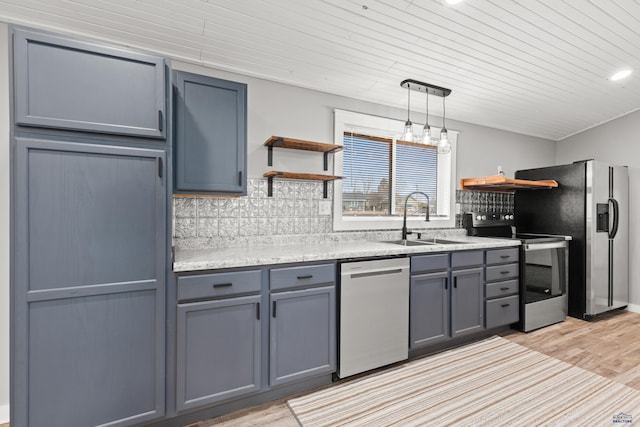 kitchen featuring open shelves, stainless steel appliances, a sink, and gray cabinetry