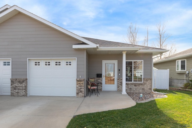 view of front of house featuring a garage, driveway, a shingled roof, a front lawn, and brick siding