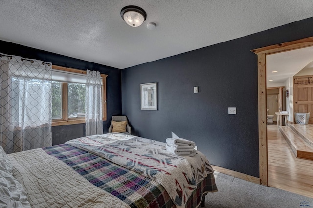 bedroom featuring a textured ceiling and wood finished floors