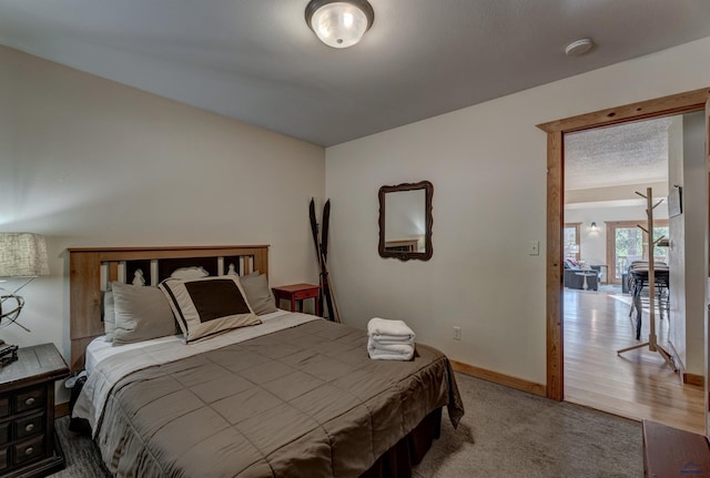 carpeted bedroom featuring baseboards and a textured ceiling