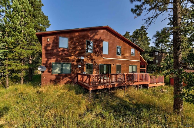 rear view of house featuring a wooden deck