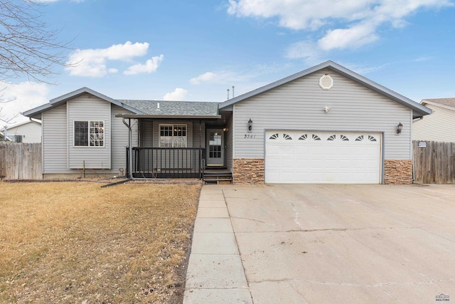 single story home featuring an attached garage, covered porch, fence, driveway, and stone siding