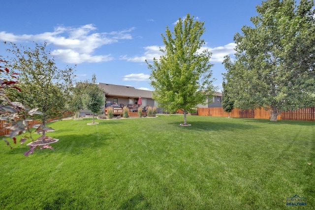 view of yard featuring fence, a fire pit, and a wooden deck