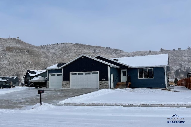 single story home featuring an attached garage and stone siding