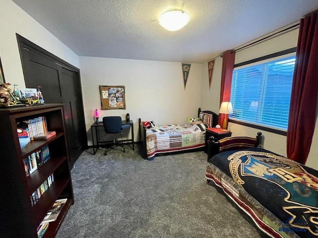 bedroom with a textured ceiling and carpet