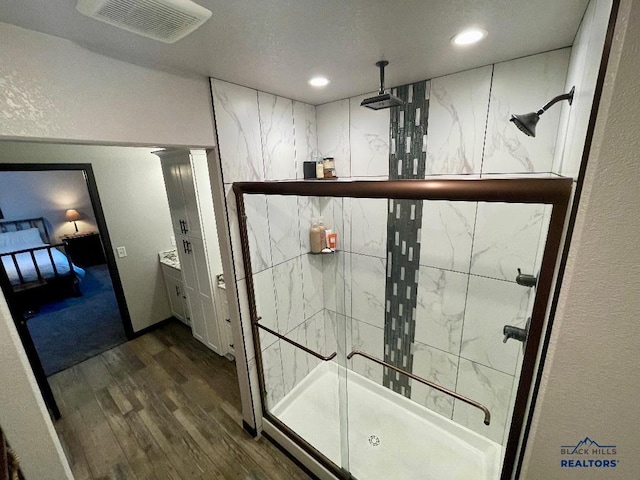 full bathroom with recessed lighting, wood finished floors, visible vents, a shower stall, and ensuite bath