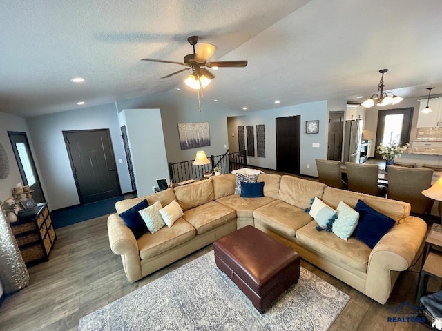 living room featuring a textured ceiling, vaulted ceiling, wood finished floors, and recessed lighting