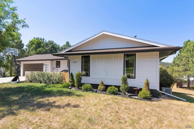 view of front facade featuring a garage, driveway, central AC, and a front yard