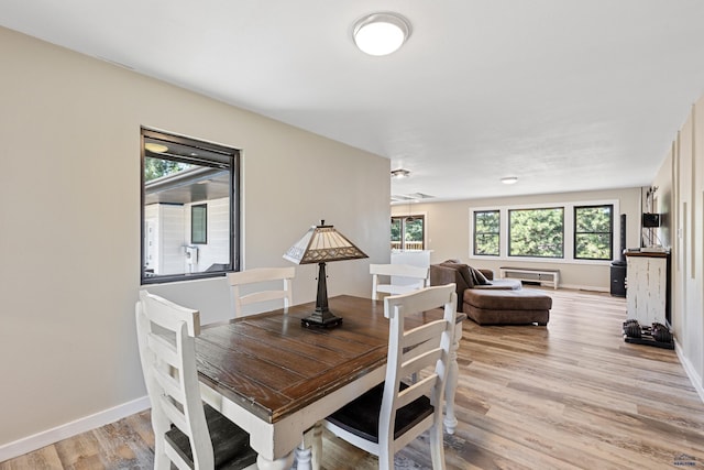 dining area featuring plenty of natural light, light wood-style flooring, and baseboards