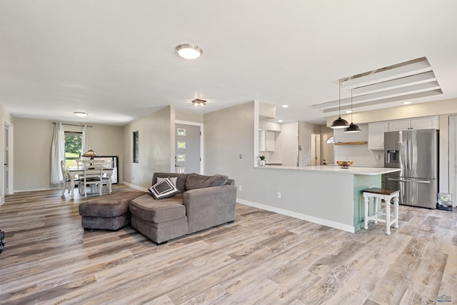 living room featuring light wood-type flooring and baseboards