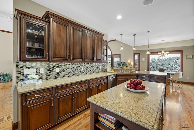 kitchen with a healthy amount of sunlight, light wood-type flooring, a sink, and decorative backsplash