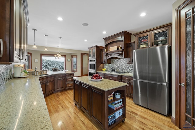 kitchen featuring light wood finished floors, appliances with stainless steel finishes, and open shelves