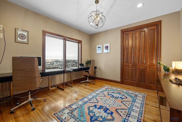 office space featuring an inviting chandelier, baseboards, wood finished floors, and recessed lighting