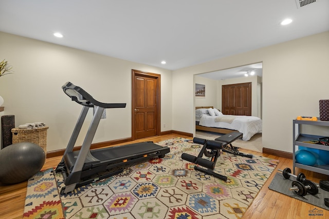 exercise area featuring recessed lighting, visible vents, baseboards, and wood finished floors